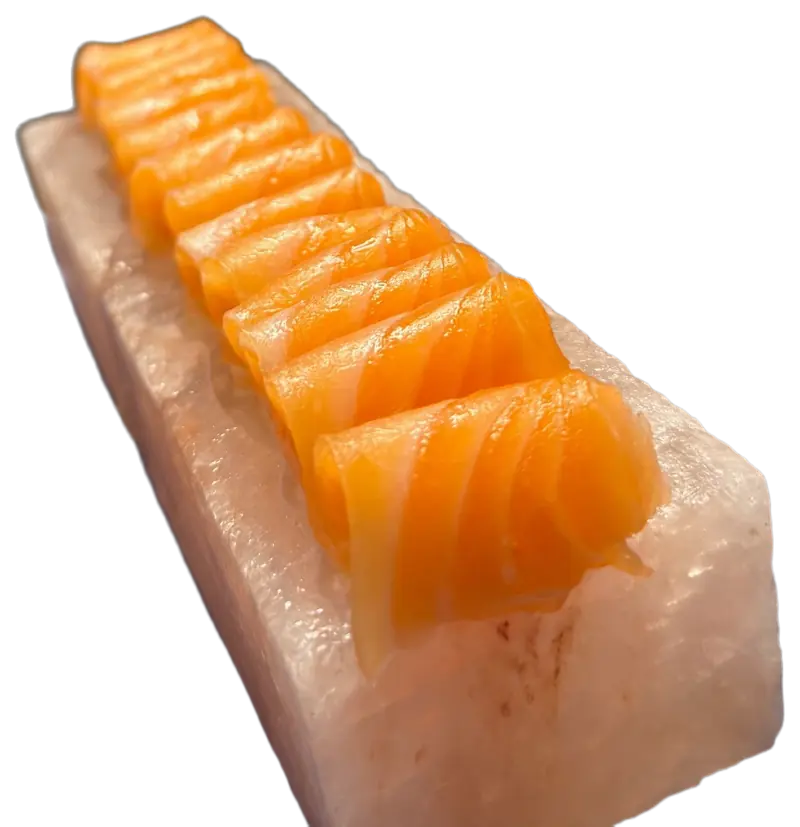Fatias de salmão enroladas sobre um bloco de sal rosa